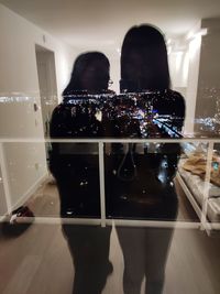 Reflection of people on illuminated glass at restaurant
