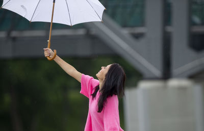 Woman holding umbrella standing outdoors