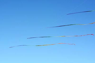 Low angle view of kite flying against clear blue sky