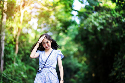 Portrait of smiling young woman standing in forest