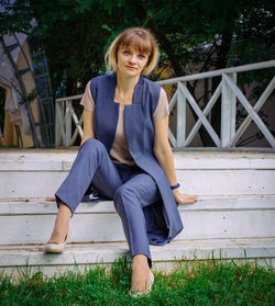 Portrait of smiling young woman sitting on staircase