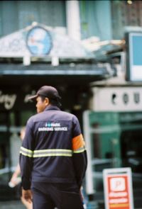 Rear view of man standing on city street