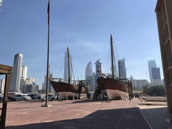 Sailboats in city against sky