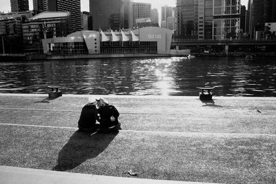 People sitting by buildings in city