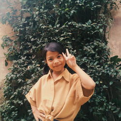 Portrait of teenage girl standing against plants