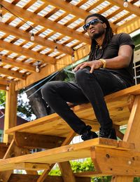 Low angle view of young man sitting on seat