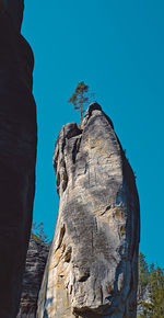 Low angle view of rock formation against clear blue sky