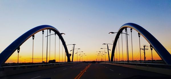 Cars on road against sky during sunset