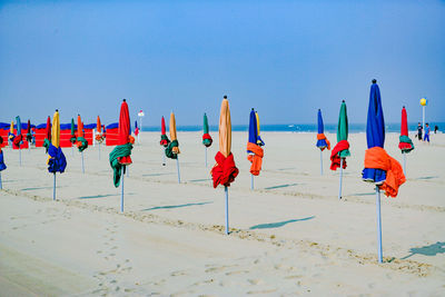 Multi colored umbrellas on beach against clear blue sky
