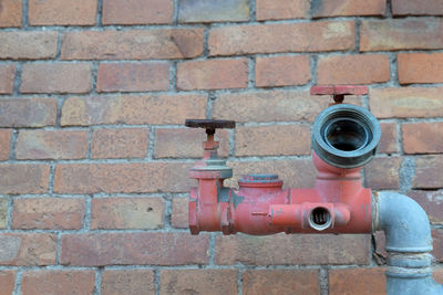 Close-up of fire hydrant against brick wall