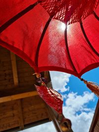 Low angle view of red bell hanging from roof