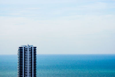 Sea by buildings against sky