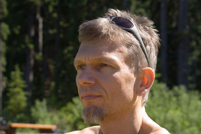 Close-up of man looking away in sunny day