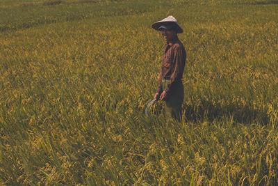Full length of woman wearing hat on field