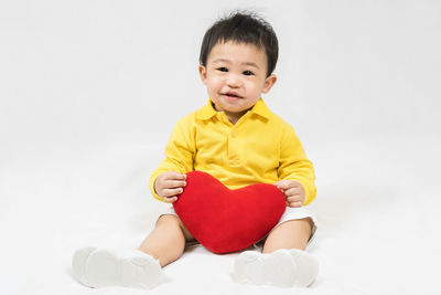 Portrait of cute baby boy standing against white background