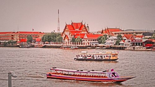 Boats in river with buildings in background