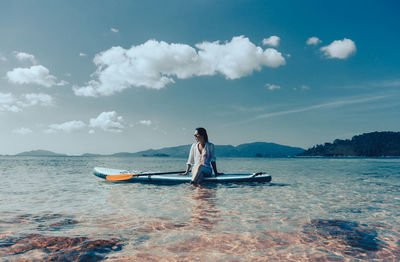 Rear view of man standing in sea against sky