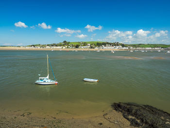 Sailboats moored on sea against sky