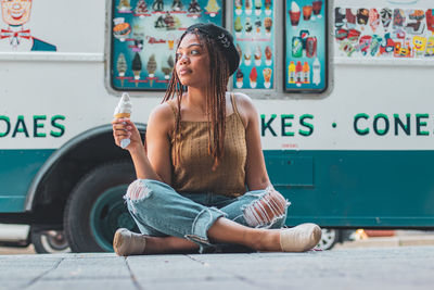 Woman looking away while sitting outdoors