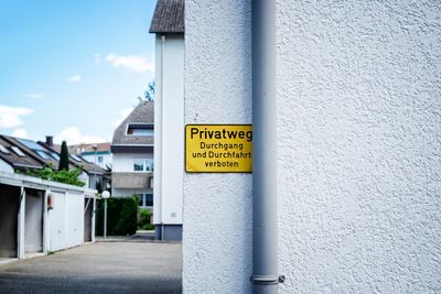 Information sign on pole against building