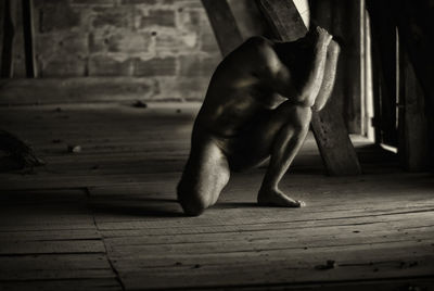 Sad naked man in abandoned building