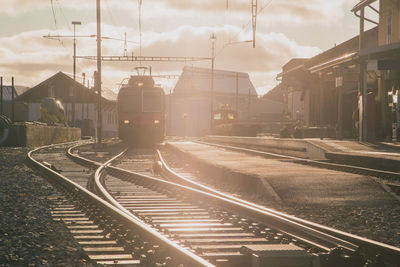 Railroad tracks in city against sky