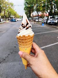 Midsection of person holding ice cream in city