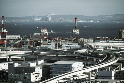 High angle view of city by sea against sky