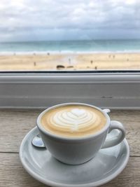Coffee cup on table overlooking the beach