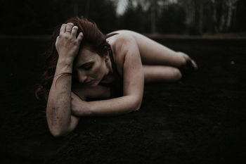 PORTRAIT OF YOUNG WOMAN LYING DOWN ON FLOOR