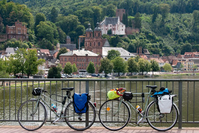 Bicycle by river against buildings in city