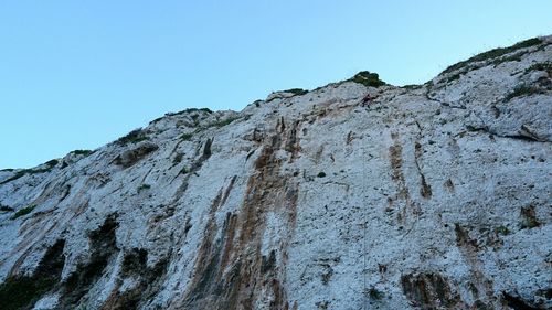 Low angle view of rock formations against clear blue sky