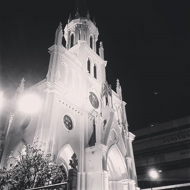 low angle view, religion, architecture, place of worship, built structure, church, building exterior, spirituality, cathedral, illuminated, night, sky, cross, history, famous place, clear sky, travel destinations, outdoors