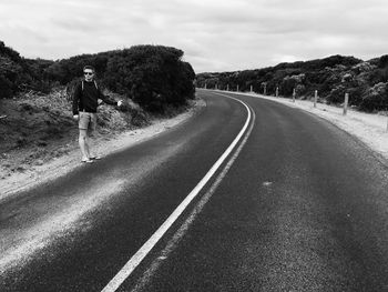 Road by trees against sky