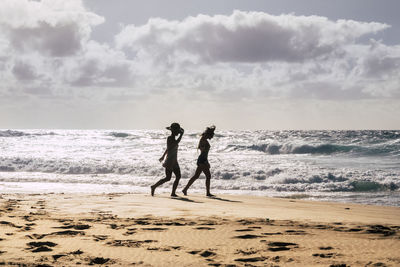 People at beach against sky