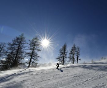 Low angle view of woman skiing on snow covered mountain