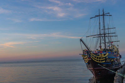 Sailboat in sea against sky during sunset