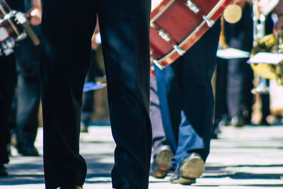 Low section of people walking on street in city