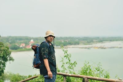 Portrait of young man standing against sky