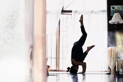 Rear view of woman standing against wall