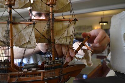 Man fixing miniature ship