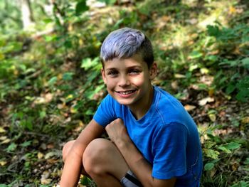Portrait of smiling boy sitting outdoors