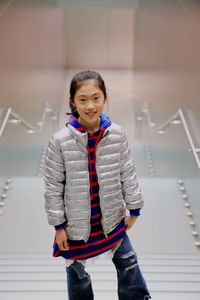 Portrait of cute smiling girl standing on steps