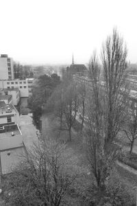 Houses and bare trees against clear sky