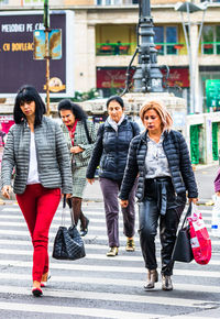 Full length of women walking on street in city