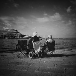 Rear view of senior couple overlooking calm sea