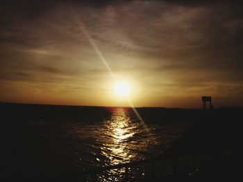 Scenic view of sea against dramatic sky during sunset