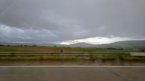 Road by landscape against sky
