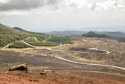 Scenic view of road by mountains against sky