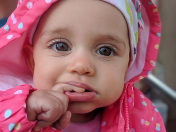 Close-up portrait of cute baby girl wearing pink hooded shirt